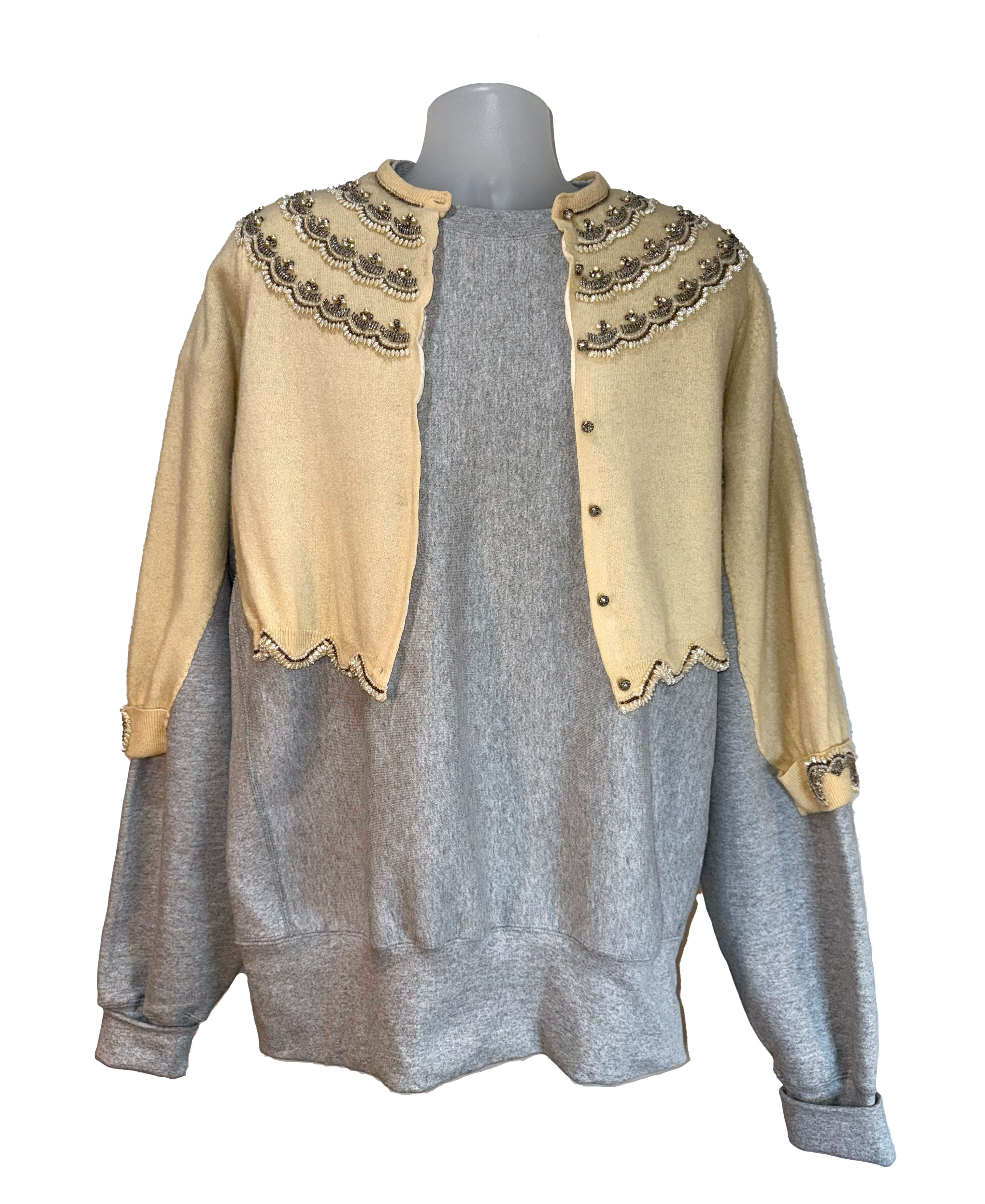 Gray sweater with beige embroidered shoulders on a mannequin against a white background