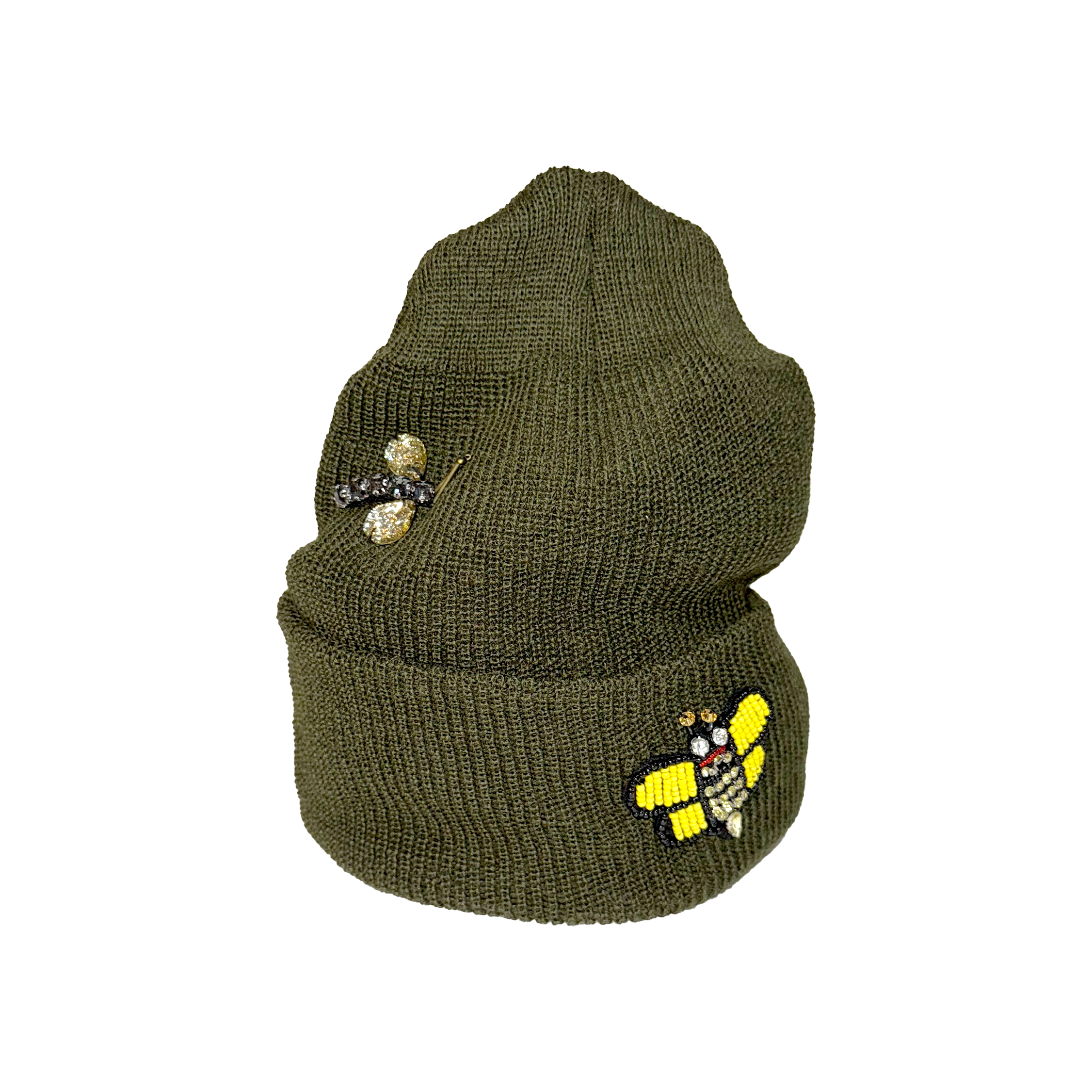 Green knit beanie with decorative pins on a white background
