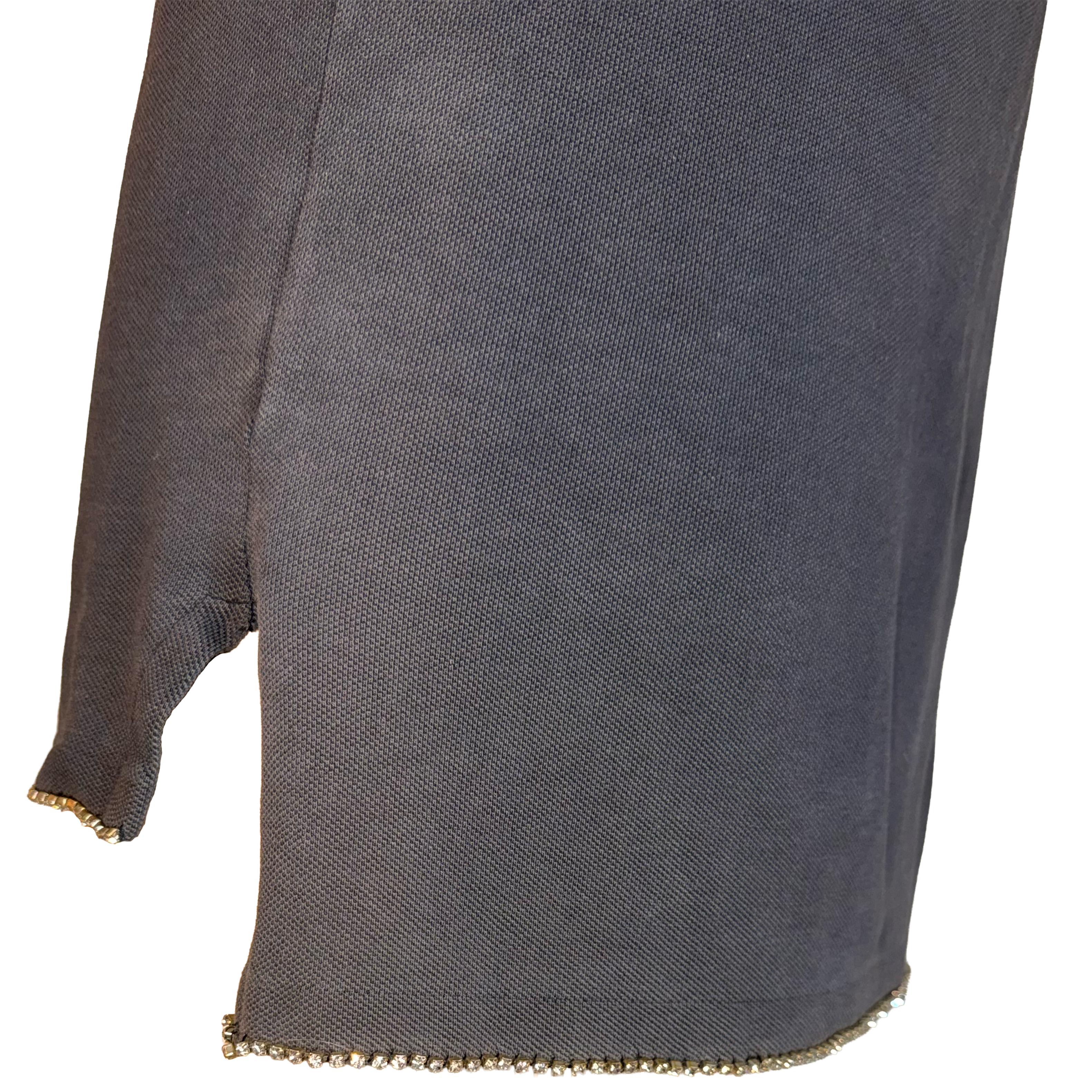 Close-up of a dark gray textured knit garment, showing a side slit with a gold beaded trim at the hem and sleeve cuff, against a white background.