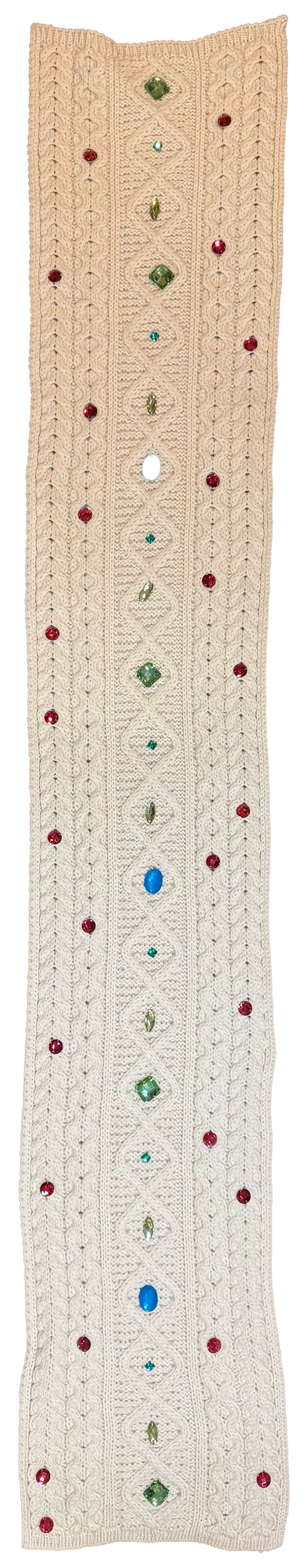 A long cream-colored knit sweater or cardigan with a textured cable knit pattern, decorated with small colorful rhinestone embellishments in red, green, and blue along the center and scattered dots.