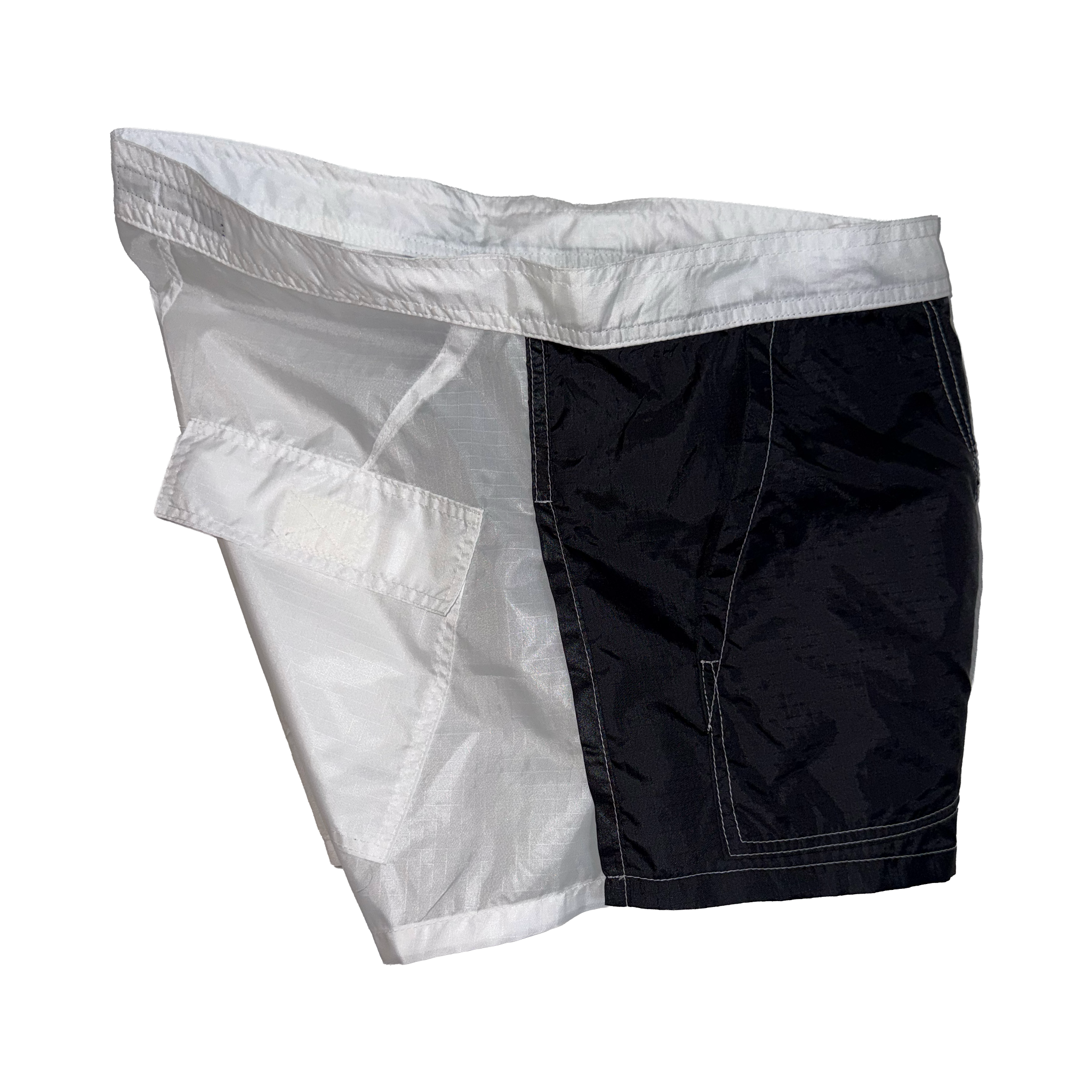 A pair of shorts made from a split-color fabric, featuring a white left side and a black right side, with a white waistband and white contrast stitching.