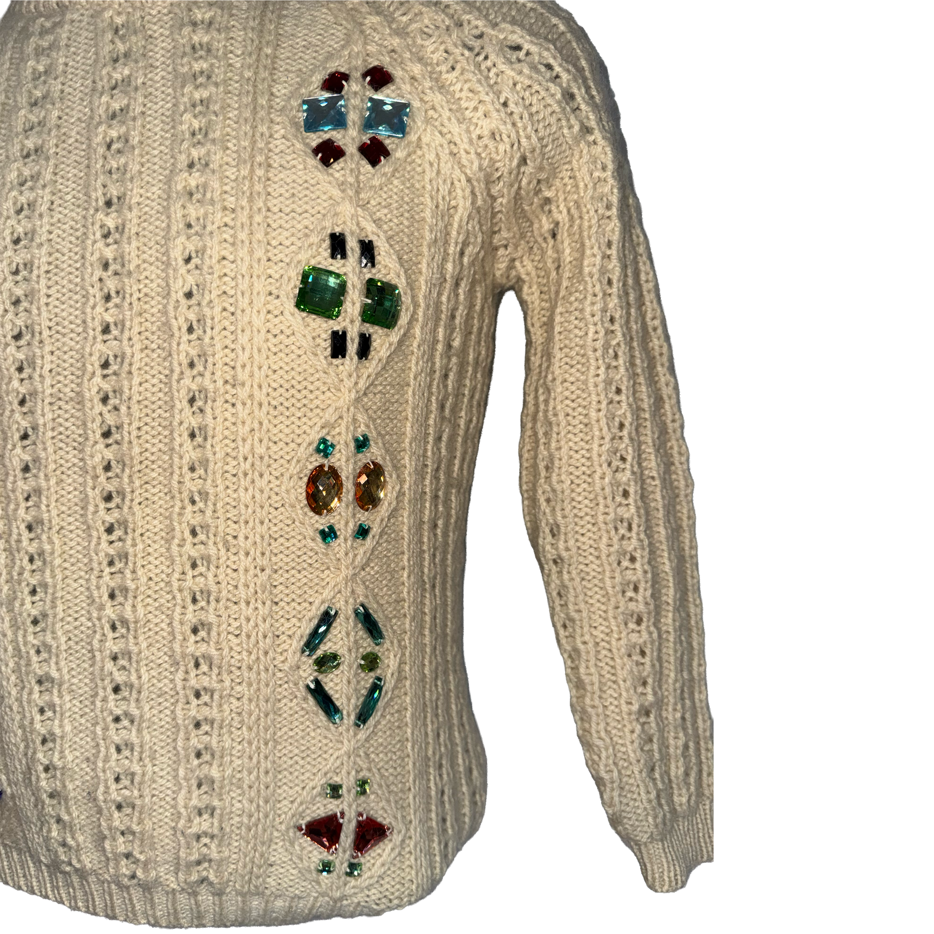 An off-white cable-knit sweater with a vertical row of colorful rhinestone embellishments on the back, set against a plain white background.