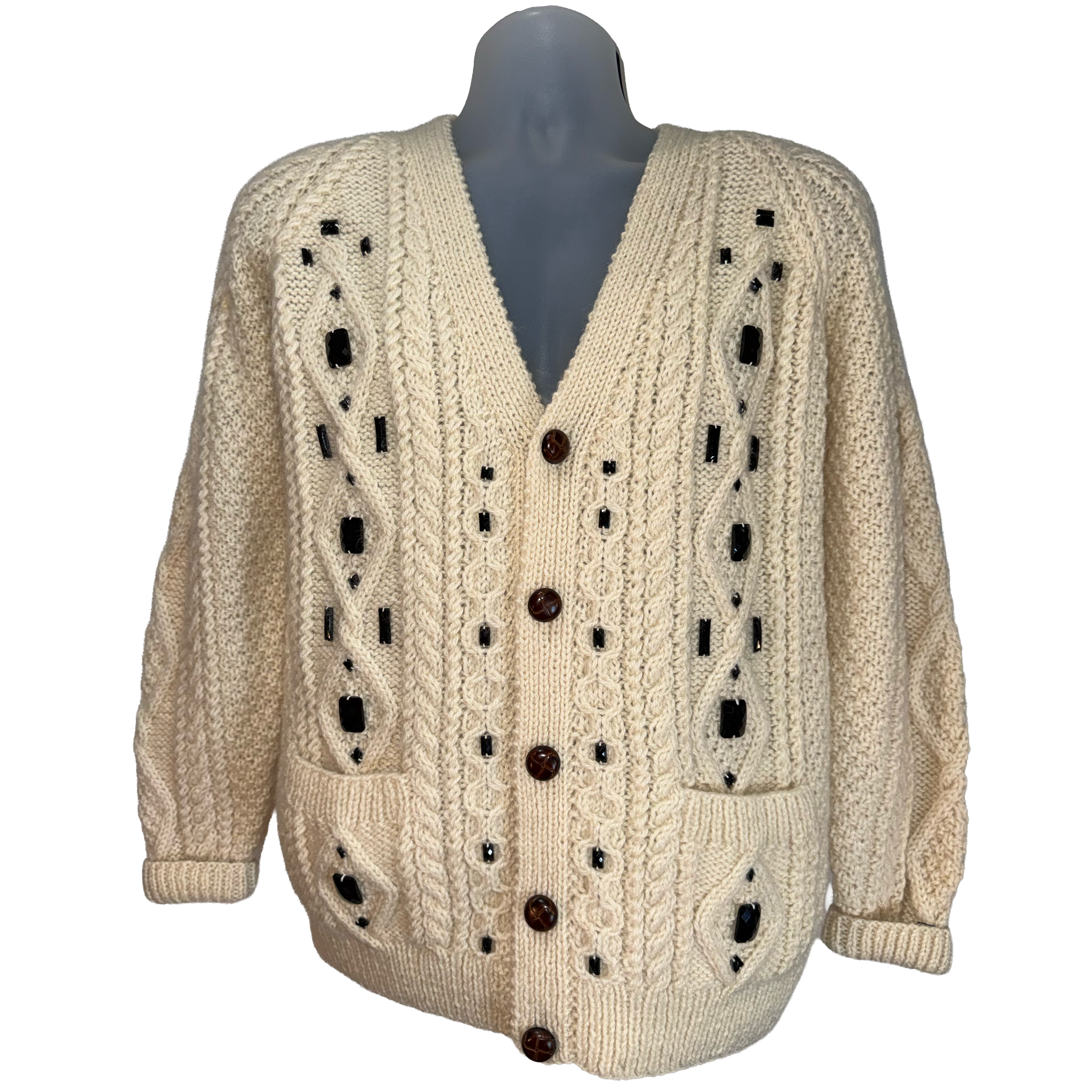 Cream cable-knit cardigan sweater with dark brown and black decorative buttons.
