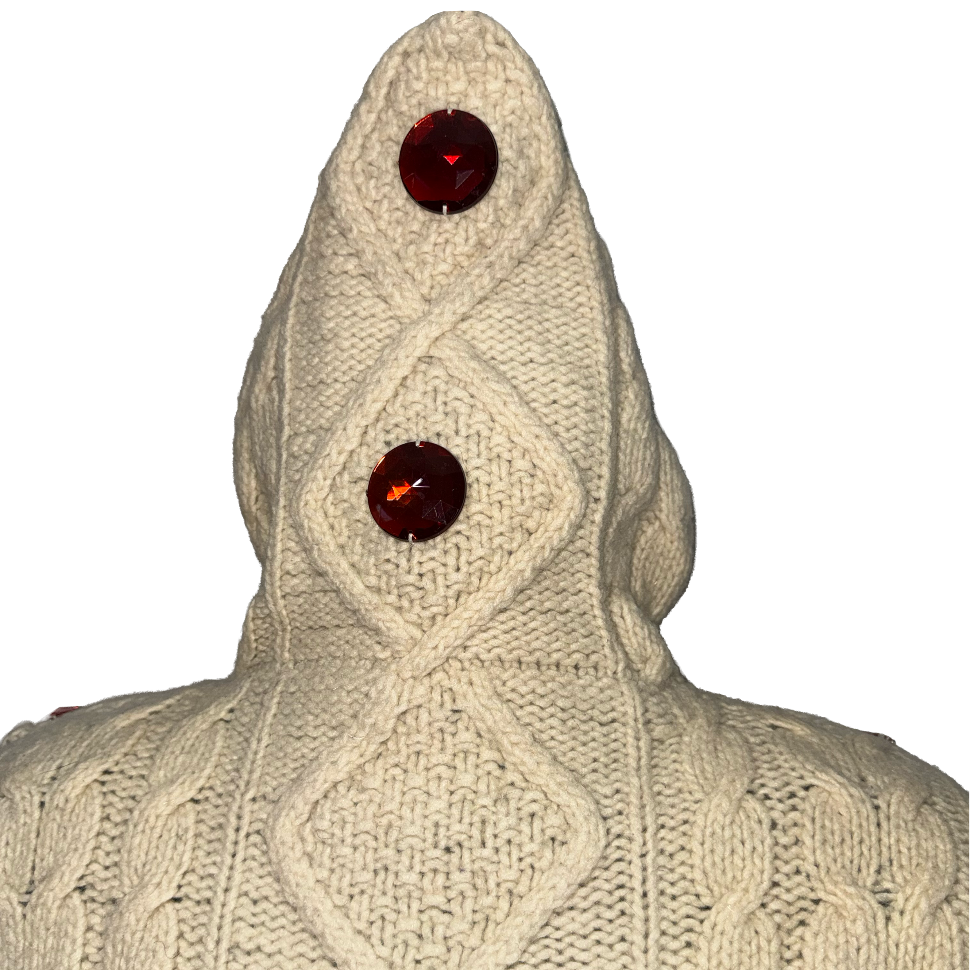 A cream-colored cable-knit hooded sweater with two large, faceted dark red gemstones set into the hood, shown against a plain white background.