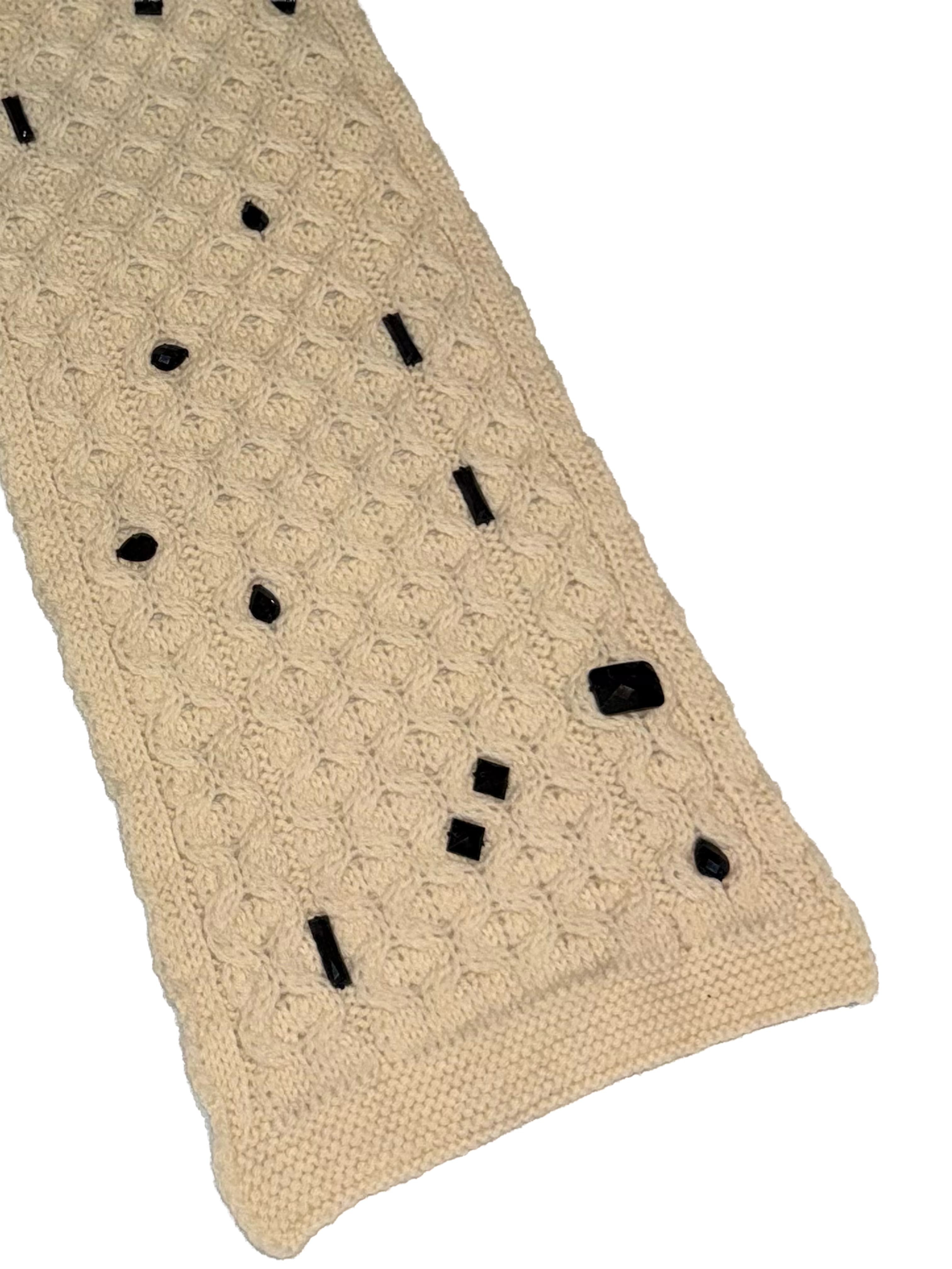 A cream-colored knit scarf with a textured pattern and scattered black buttons, shown on a plain white background.
